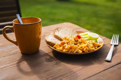 a table with a plate of food and a cup of coffee at Maringotka u Krkavčích skal in Křižany