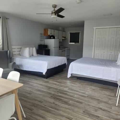 a hotel room with two beds and a kitchen at Poplars Motel on the lake in Osoyoos