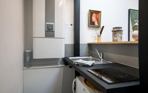 une cuisine avec un évier et un plan de travail dans l'établissement Le minimaliste pk fibre clim terrasse, à Millau