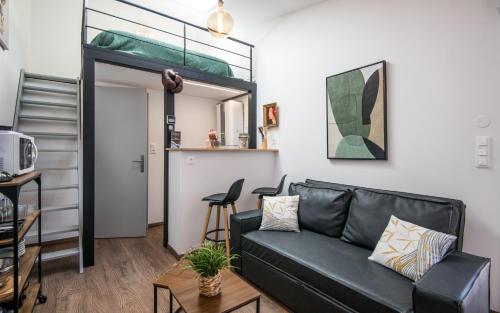 - un salon avec un canapé en cuir noir et un escalier dans l'établissement Le minimaliste pk fibre clim terrasse, à Millau