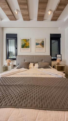 a large bed in a bedroom with two windows at Leos Apartments Apart3 in Side
