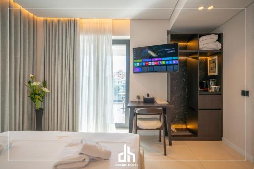 a hotel room with a bed and a desk and a tv at DREAM HOTEL SARANDA in Sarandë