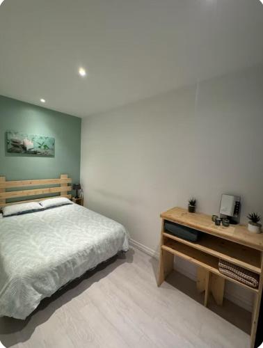 - une chambre avec un lit et un bureau en bois dans l'établissement ● Le Bigourdan ● Sanctuaires - Calme - Wifi - Park, à Lourdes