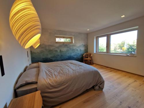 une chambre avec un lit et une grande fenêtre dans l'établissement Appartement design dans un écrin végétal, à Scherwiller