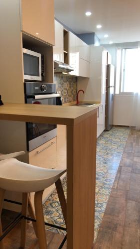 a kitchen with a wooden table and a counter top at Casa Hermosa Draria in Matriouene