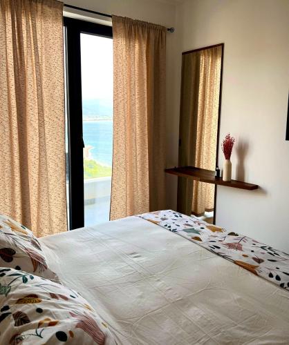 una camera da letto con un letto e una grande finestra di Puhiza Apartment a Lezhë (Alessio)