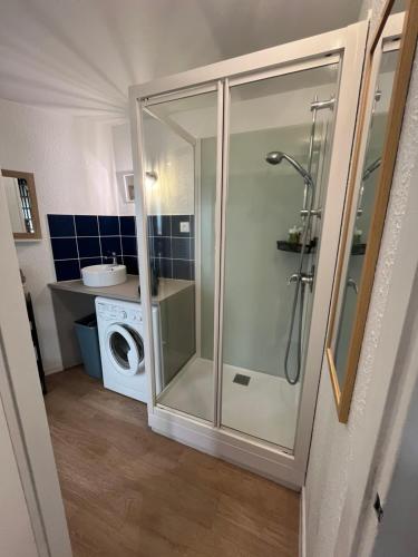 La salle de bains est pourvue d'une douche en verre et d'un lave-linge. dans l'établissement Appartement quartier des Minimes avec piscine, parking, en bordure du port à La Rochelle, à La Rochelle