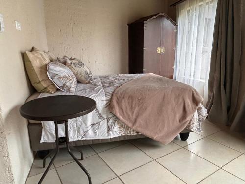a bedroom with a bed with a table and a table at Clansthal Bush Cottage in Clausthal