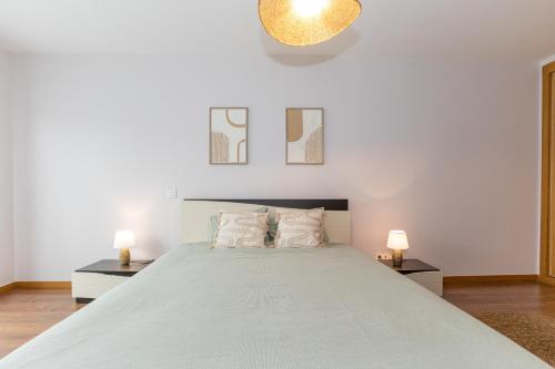 a bedroom with a large bed with two lamps at Charming Two-Bedroom Apartment in Zambujeira do Mar by Golden Zenith in Zambujeira do Mar