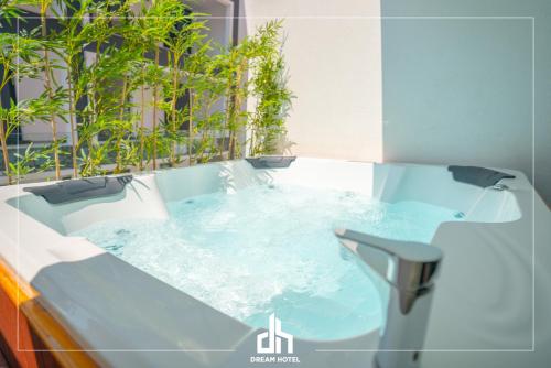 a jacuzzi tub in a bathroom with plants at DREAM HOTEL SARANDA in Sarandë