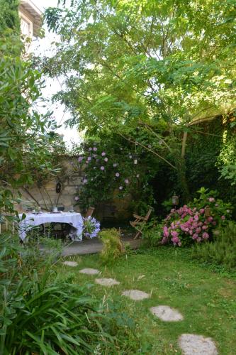 a garden with a table and some flowers at la maison in Libourne