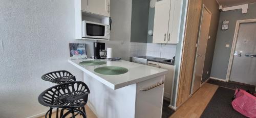 a small kitchen with a sink and a microwave at Comfortable studio close to Oulu center, free parking in Oulu
