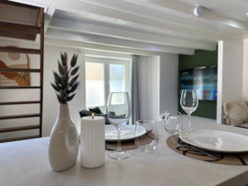 - une table à manger avec des verres à vin et un vase dans l'établissement Cruz House, à Châtenoy-le-Royal
