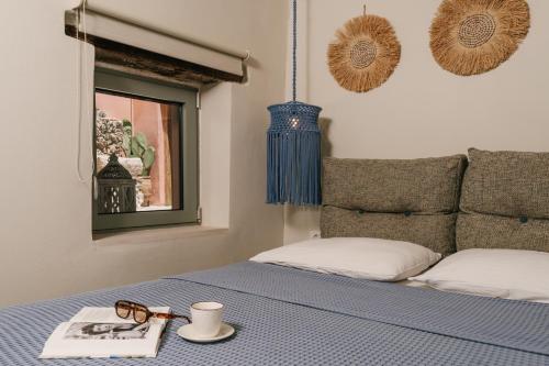a bed with a pair of glasses and a book at koritos countryhouse in Agios Leon