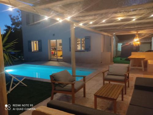 - une piscine avec des chaises et une table à côté d'une maison dans l'établissement Villa T5 Les Volets Bleus, piscine, à l'entrée de Cassis et de ses calanques, à Roquefort-la-Bédoule