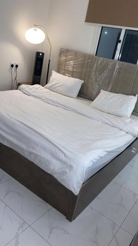 a large bed with white sheets and pillows at شقة مخدومة VIp in Hafr Al Baten