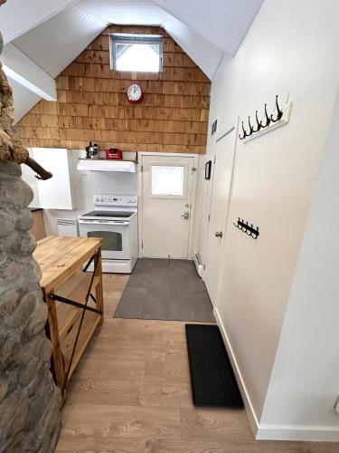 a kitchen with a white refrigerator and a table at Le refuge de la petite rivière in Saint Mathieu Du Parc