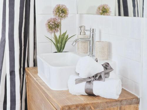 a bathroom with a sink and towels and flowers at Kings cross station 1 Bed flat for 4 in London