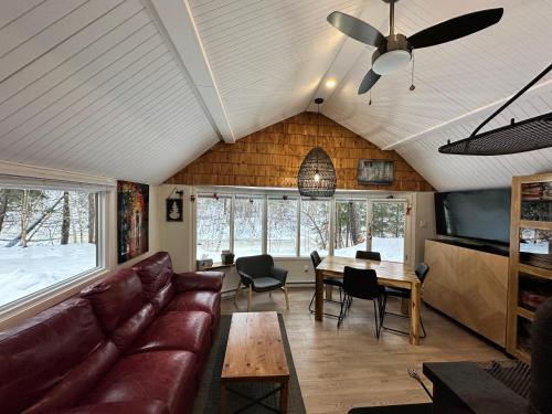 a living room with a couch and a table at Le refuge de la petite rivière in Saint Mathieu Du Parc