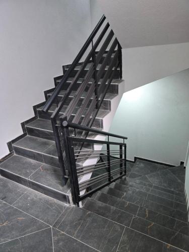 a staircase with metal railings and a tile floor at Kmb Apartment in Kragujevac