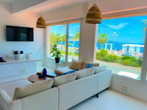 un salon avec un canapé blanc et une grande fenêtre dans l'établissement Les pieds dans l eau, à Nice