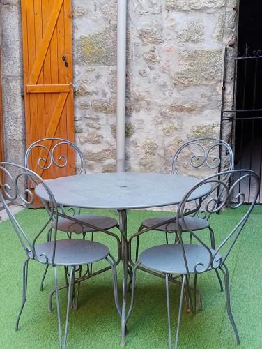 a metal table and two chairs with a table and a door at gite morvan in Lormes