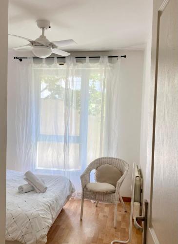 une chambre avec un lit, une chaise et une fenêtre dans l'établissement Appartement Résidence Quartier Vilette Paul Bert BOX GARAGE, à Lyon