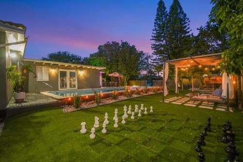 a backyard with a game of dominoes in the grass at La Playita 4-BR Heated Pool Miami 16 Guests in Miami