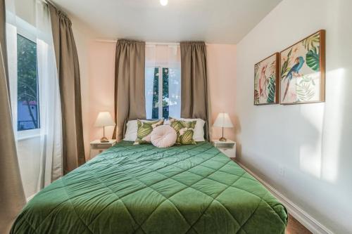 a bedroom with a green bed with two lamps at La Playita 4-BR Heated Pool Miami 16 Guests in Miami