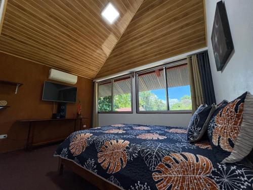 a bedroom with a bed in a room with windows at Peregrine Nest Puerto Jimenez in Puerto Jiménez
