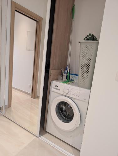 - un lave-linge dans une pièce avec un miroir dans l'établissement Marina Baie des Anges, Sublime Studio rénové, à Villeneuve-Loubet