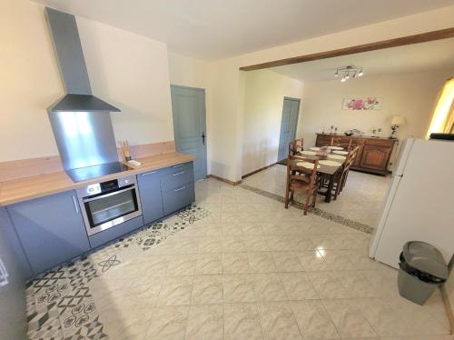 a kitchen with a table and a stove top oven at Grande maison à la campagne in Bourgnac