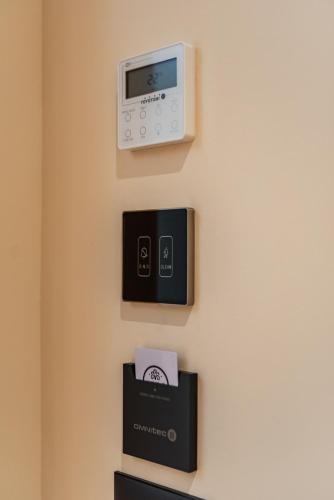 a wall with a clock and a box on a wall at Arbo Boutique Hotel in Durrës