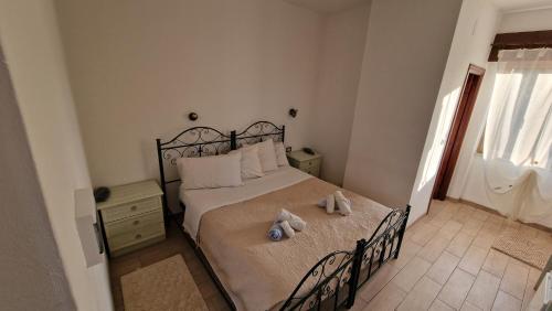 a bedroom with a bed with two stuffed animals on it at Hotel La Vela in Valledoria