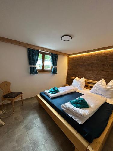 a bedroom with two beds and a chair at Linsingerhof in Achenkirch