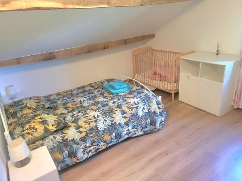 a bedroom with a bed and a crib at Grande maison à la campagne in Bourgnac
