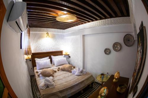 a bedroom with two dogs laying on a bed at Dar Lalamoune in Fès