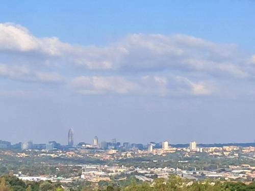 a view of a city from the top of a hill at Bandile's cosy home in Honeydew