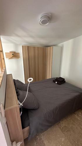 - une chambre avec un grand lit et une armoire en bois dans l'établissement Lappartement du sud, à Saint-Quentin-la-Poterie