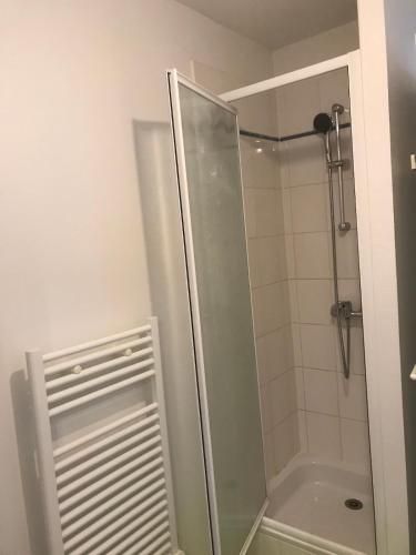 une douche avec une porte vitrée dans une salle de bain dans l'établissement Laïa, studio type Scandinave, wifi, parking, à La Rochelle