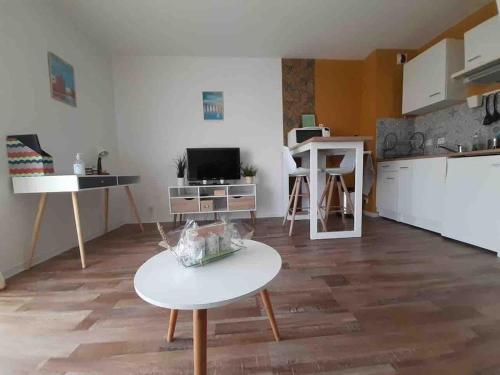 un salon avec une table et une cuisine dans l'établissement Laïa, studio type Scandinave, wifi, parking, à La Rochelle