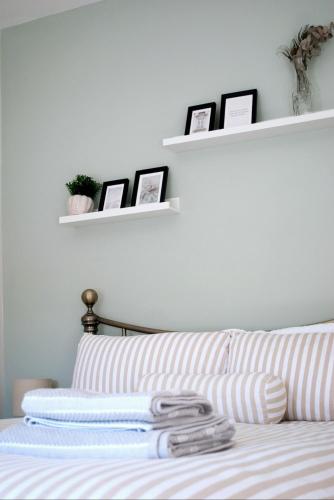a bedroom with a bed with three pictures on shelves at Cottage Corner NI in Newtownards