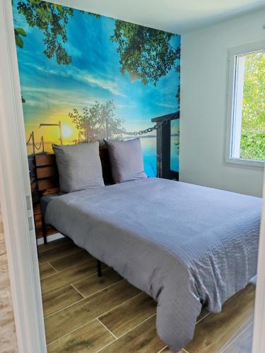 a bedroom with a bed with a painting on the wall at Le temps de la pause 1 in Cepoy