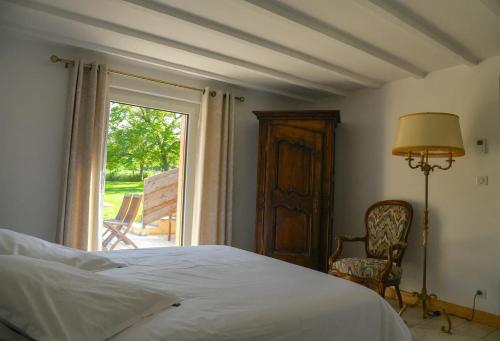une chambre avec un lit, une fenêtre et une chaise dans l'établissement Villa charmante avec piscine privée à Castels_2, à Finsac