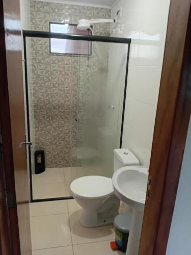 a bathroom with a toilet and a glass shower at Pousada Lagoa Azul in Penha