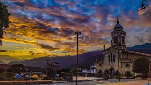 an old building with a clock tower with a sunset at Nido y Mirador El Condor Sierra Nevada Guican y El Cocuy in Güicán