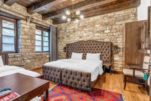 a bedroom with a large bed and a brick wall at White House Boutique Hotel & Restaurant - since 1999 in Berat