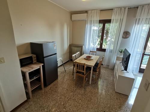 a kitchen and dining room with a table and a refrigerator at Funivia Apartment in Brescia