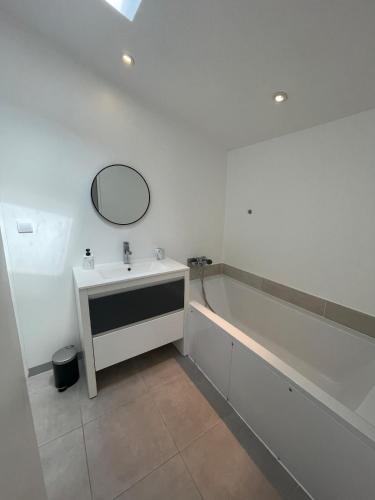 une salle de bain avec un lavabo et une baignoire dans l'établissement Bordeaux, ocean and vineyards, à Le Pian-Médoc