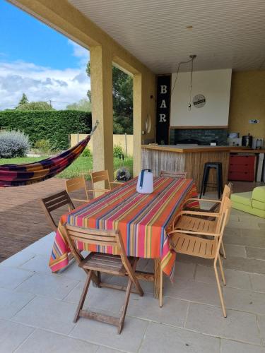 un patio avec une table et des chaises et une cuisine dans l'établissement Villa paisible avec piscine proche Toulouse, à Eaunes